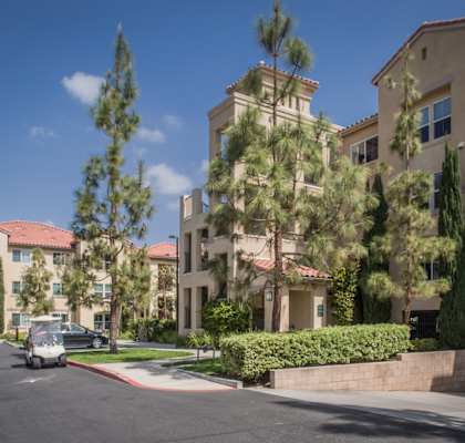 a street view of an apartment building with cars parked in front