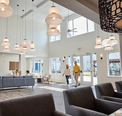 A group of people are walking through a large, open lobby area.