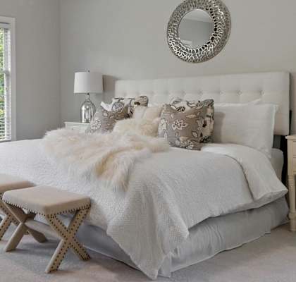 a luxurious bed with plush pillows, bedding, and side tables with lamps and decor