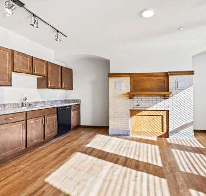 An open kitchen and living area with vaulted ceilings and recessed lighting at Horicon School Apartments