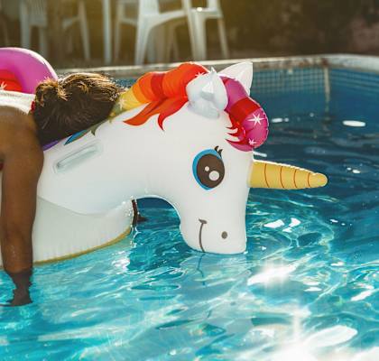 a girl sleeping on a unicorn inflatable float in a pool