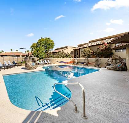 A pool with a slide and sun loungers.