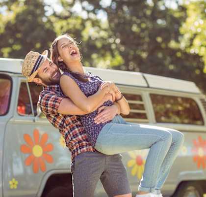 a man holding a woman in front of a van