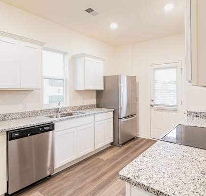 a kitchen with granite counter tops and stainless steel appliances