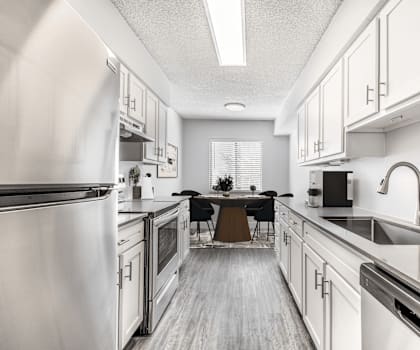 A modern kitchen with stainless steel appliances and white cabinets.