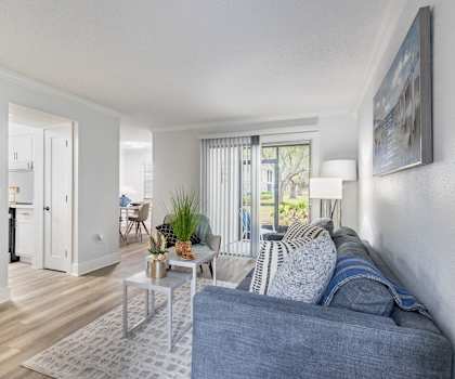 A living room with a blue couch and a white coffee table.