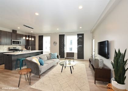 a living room and kitchen with a couch and a tv