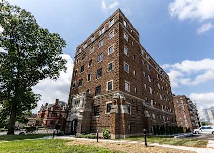 A large red brick building with a tree in front of it.