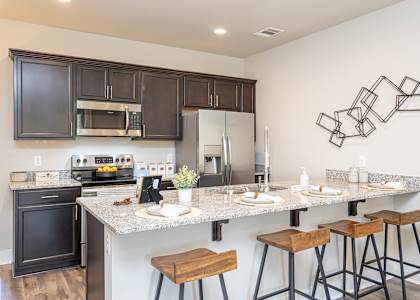 a kitchen with a long counter top with bar stools