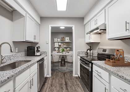 a spacious kitchen with granite counter tops and white cabinets