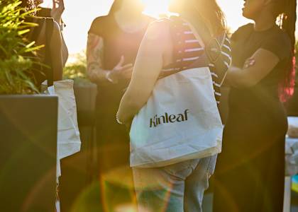 A person is holding a bag with the word "kinleaf" on it.