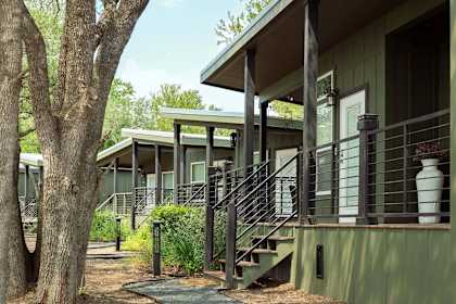 a view of the outside of a building with stairs and a tree