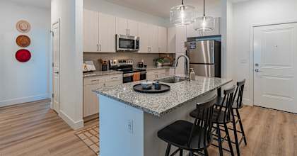 A kitchen with a granite countertop and a refrigerator.