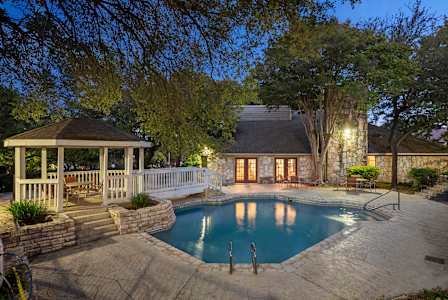 A backyard with a pool and a gazebo.