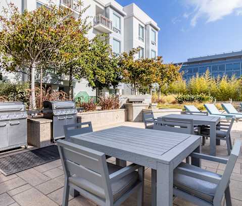 an outdoor patio with tables and chairs and barbecue grills at Strata at Mission Bay, California, 94158