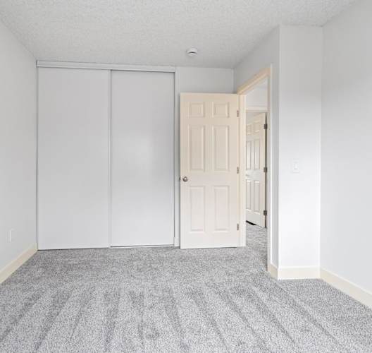 A room with a grey carpet and a white door. at Stony Creek Apartments, Santa Rosa, 95401