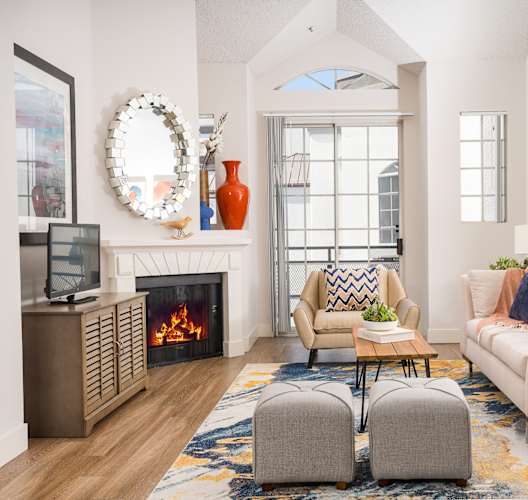 Living room with a large window and a wooden floor at The Preston Miracle Mile Apartments, Los Angeles, 90036