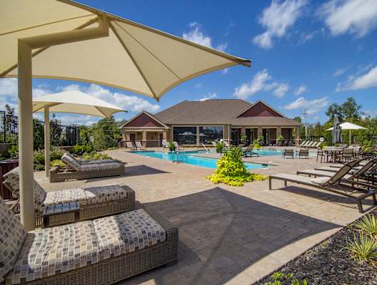A sunny day at the poolside with loungers and umbrellas.