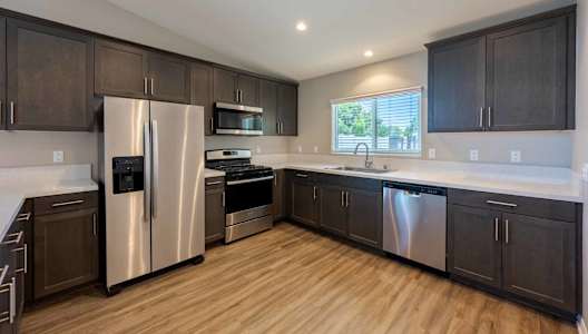 A kitchen with dark wood cabinets and stainless steel appliances.