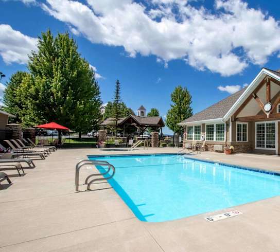 A large swimming pool in front of a house.