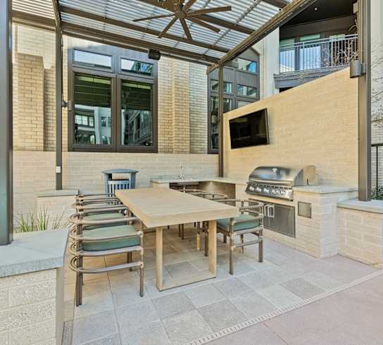 A patio with a table and chairs under a roof.