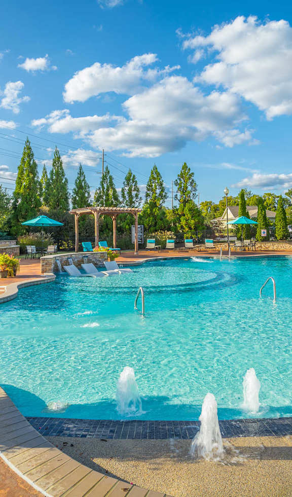 A large swimming pool with a fountain in the middle of it.