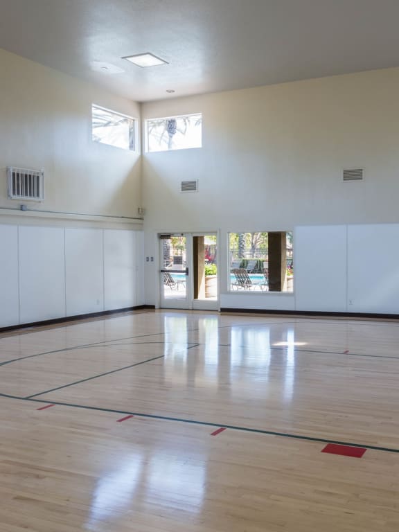 an empty gym with a basketball hoop