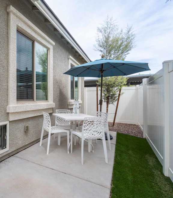 A patio with a white couch, a fireplace, and a television.