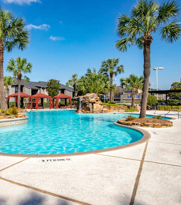A large swimming pool in front of a resort.