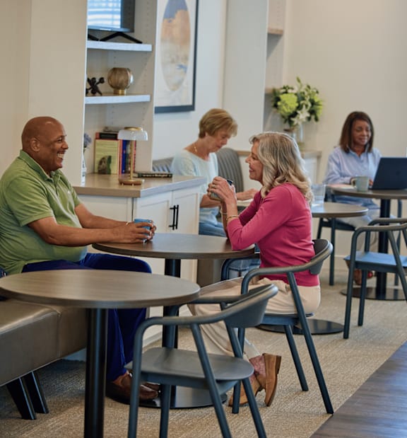 A group of people sitting around a table in a meeting room.