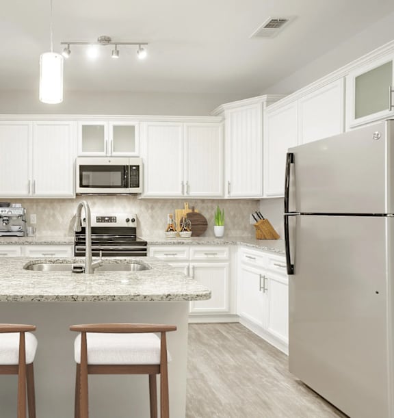 a kitchen with a marble counter top and a stainless steel refrigerator at The Beck at Hidden River, Tampa, FL, 33637