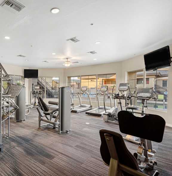 A gym with treadmills, a bench, and a weight machine.