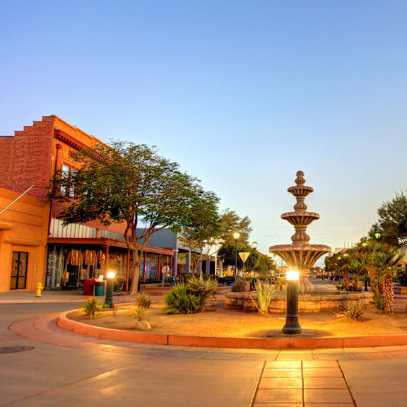 a fountain in the middle of a city street at night