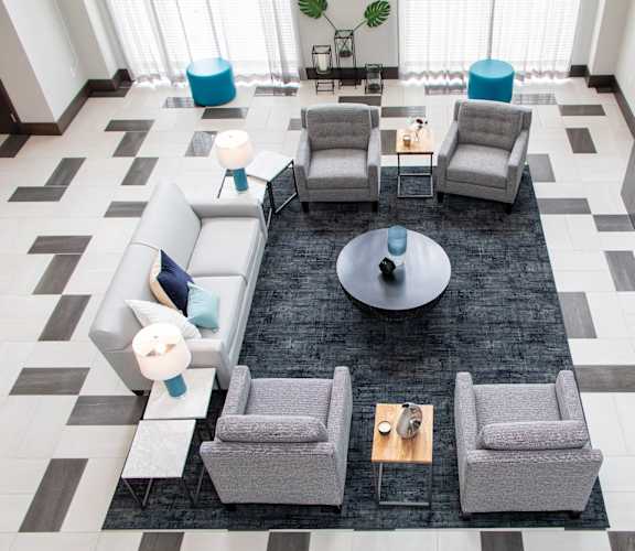 A black and white tiled floor with a grey sofa and a coffee table.