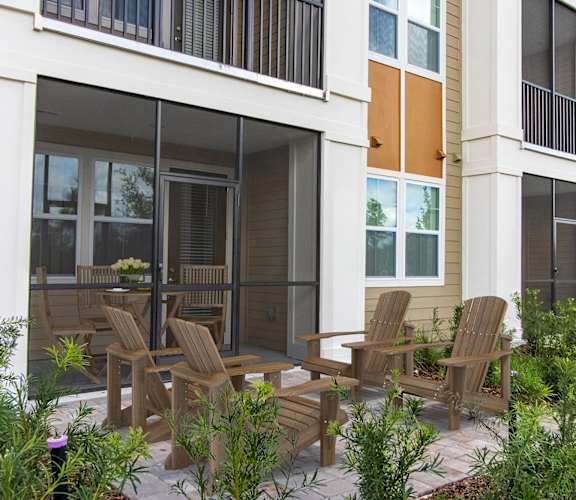 a patio with a table and chairs in front of a building