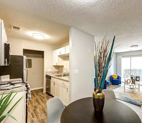 A modern kitchen with a dining table and chairs at Sedgefield Square Apartments, North Carolina, 27407