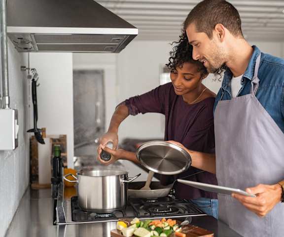 a man and a woman cooking food in a kitchen at Sandy Creek Apartments, Texas, 77807
