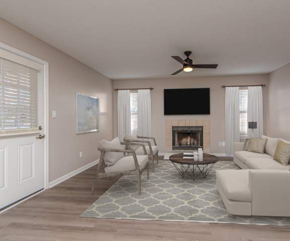 A living room with a fireplace and a television.