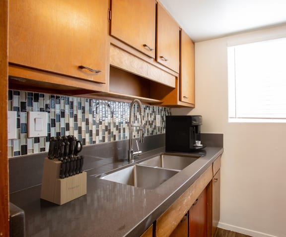 a kitchen with wooden cabinets and a stainless steel sink