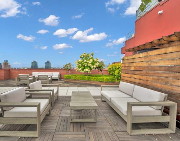 a terrace with white couches and tables on a rooftop