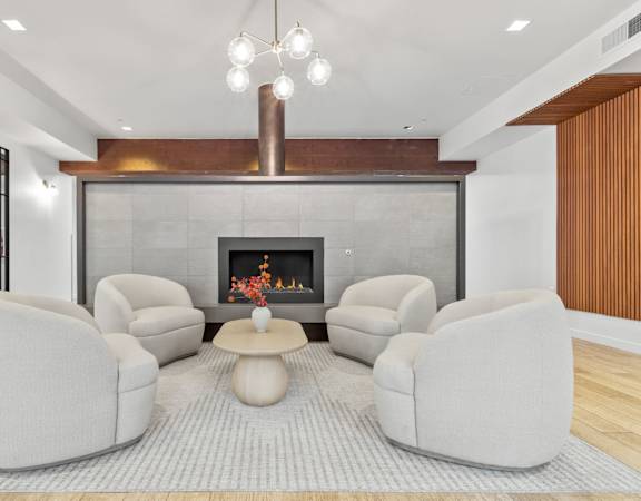 A modern living room with a fireplace and grey sofas.