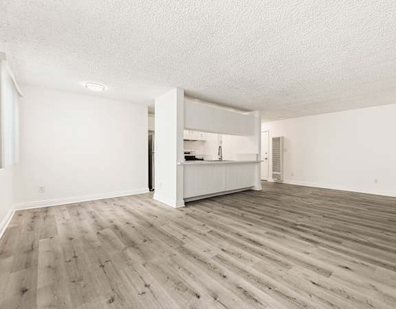 A room with wooden flooring and white walls.