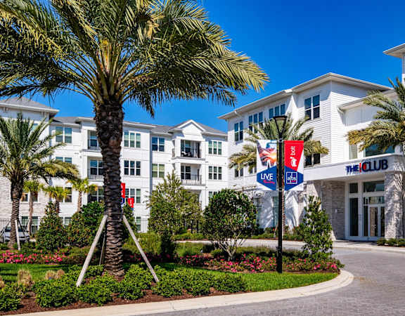 A white building with a red and blue sign that says Ine and The Club.