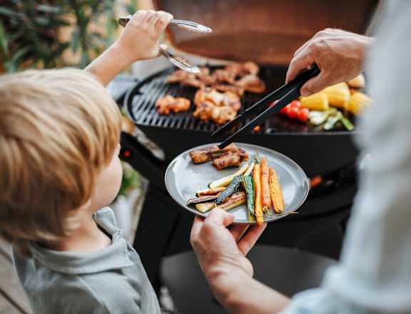 Young Boy and Older Male Relative Plating Food from a Grill at Country Woods, Ogden, UT 84401
