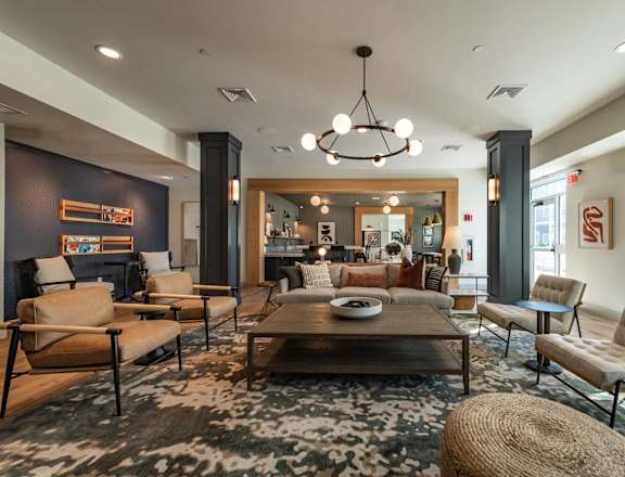 A modern living room with a large rug and a coffee table.