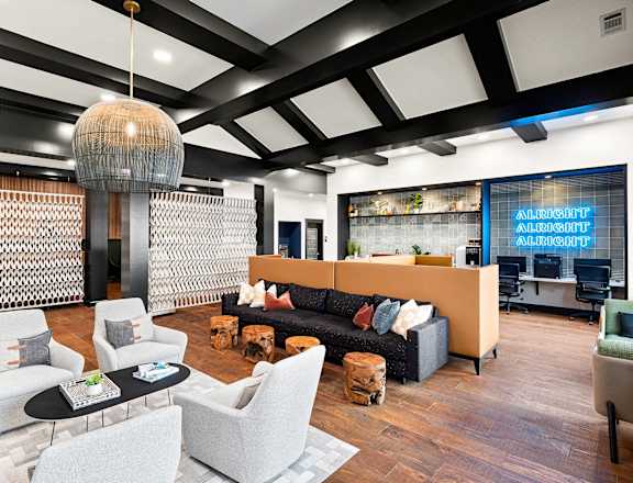 a living room with couches and chairs and a lobby area with a lobby sign