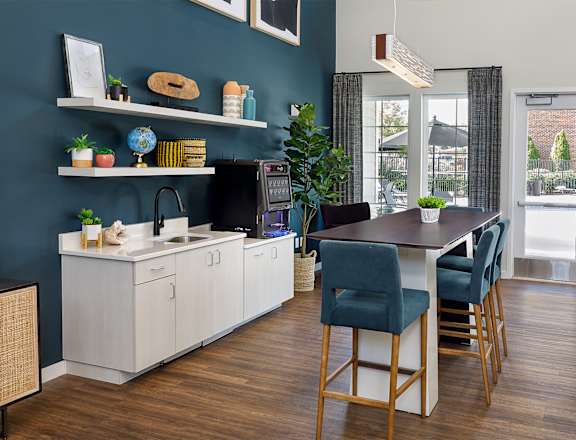 A kitchen with a blue wall and wooden floors.