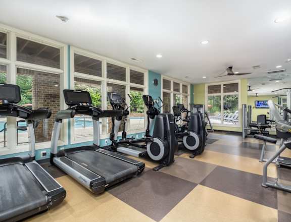 A gym with treadmills, elliptical machines, and other exercise equipment.