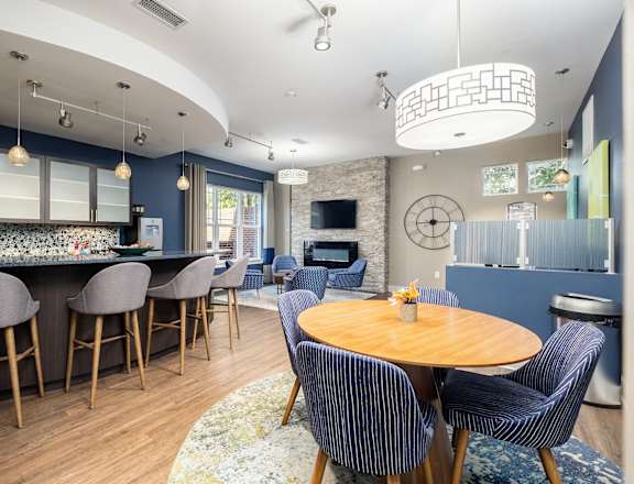 a dining room and kitchen with blue chairs and a table
