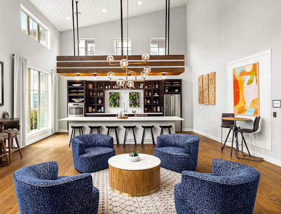 A modern living room with blue chairs and a wooden coffee table.